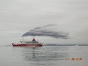 Foggy mountain and ship on water